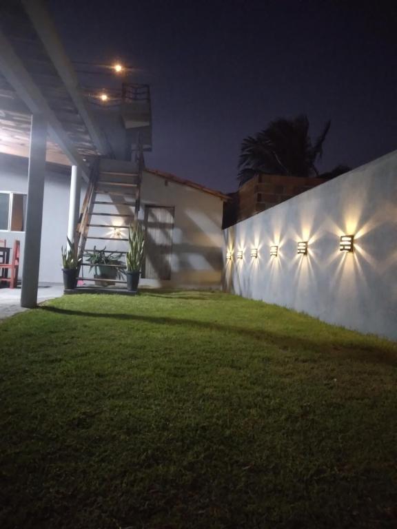 a house with lights on the wall at night at Brisa Oceanica in Itarema