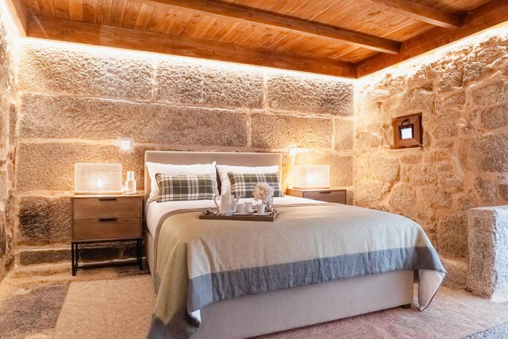 a bedroom with a bed and a stone wall at LR Vintage 96 in Vila Real