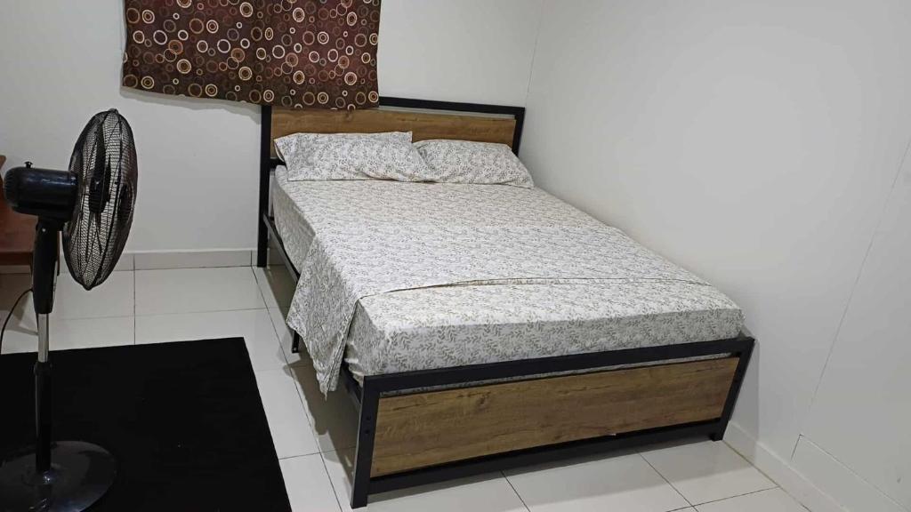 a small bed in a bedroom with a fan at Tongan Homestay in Neiafu