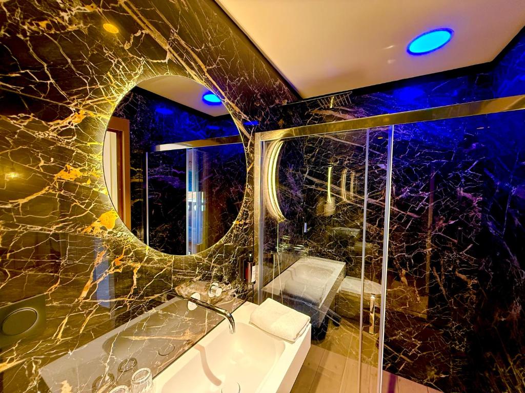 a bathroom with a tub and a sink and a mirror at Hôtel Le Mistral in Porto-Vecchio