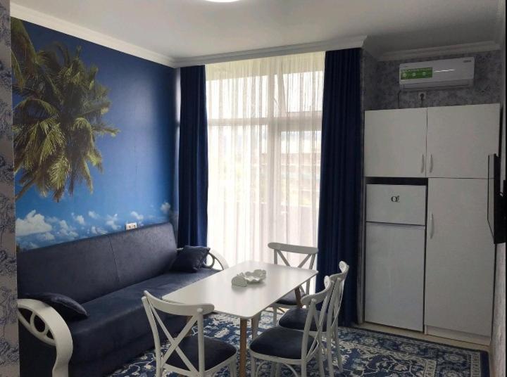 Una sala de estar con una mesa y una cocina. en apart hotel at sea, en Itʼkhvisi