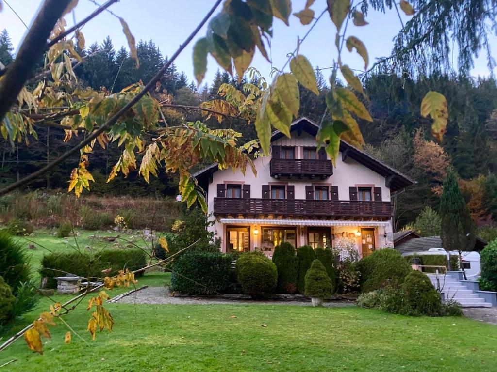a house with a green yard in front of it at Chambres d'Hôtes des Cascades St-Nicolas in Kruth