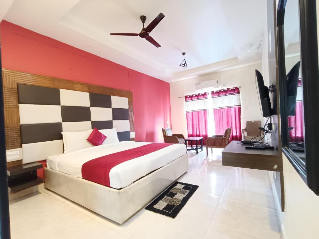 a bedroom with a bed with a red wall at Hotel New Rajdarshan in Madikeri
