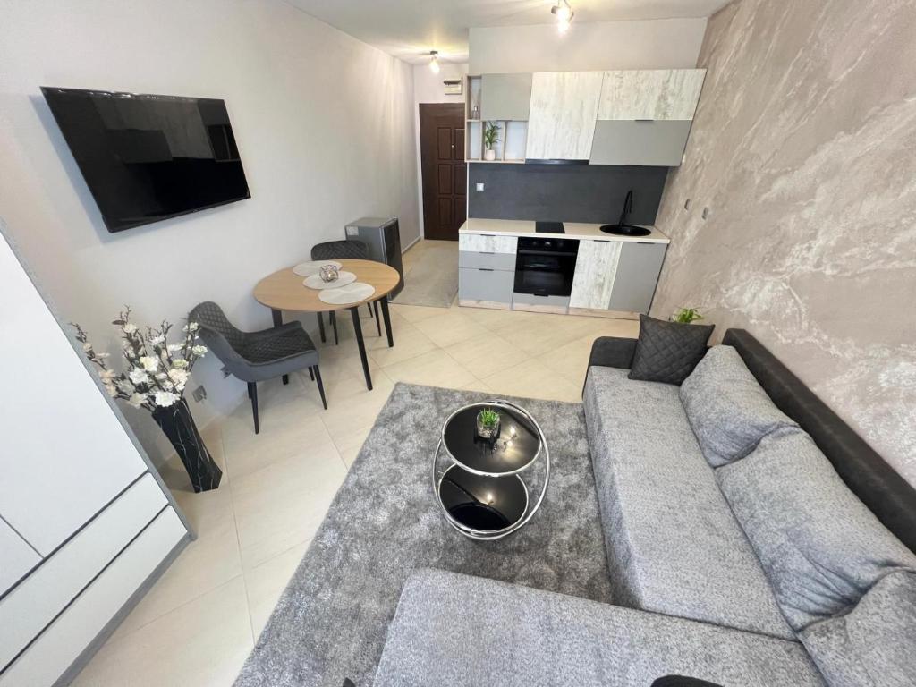 a living room with a couch and a table at Елегантно Студио В18 в комплекс Одисей, Несебър in Burgas City