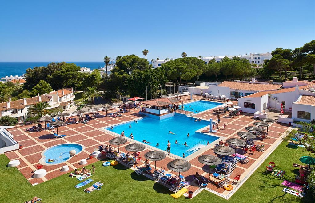 an overhead view of a swimming pool with people sitting around it at Albufeira Jardim by Umbral in Albufeira