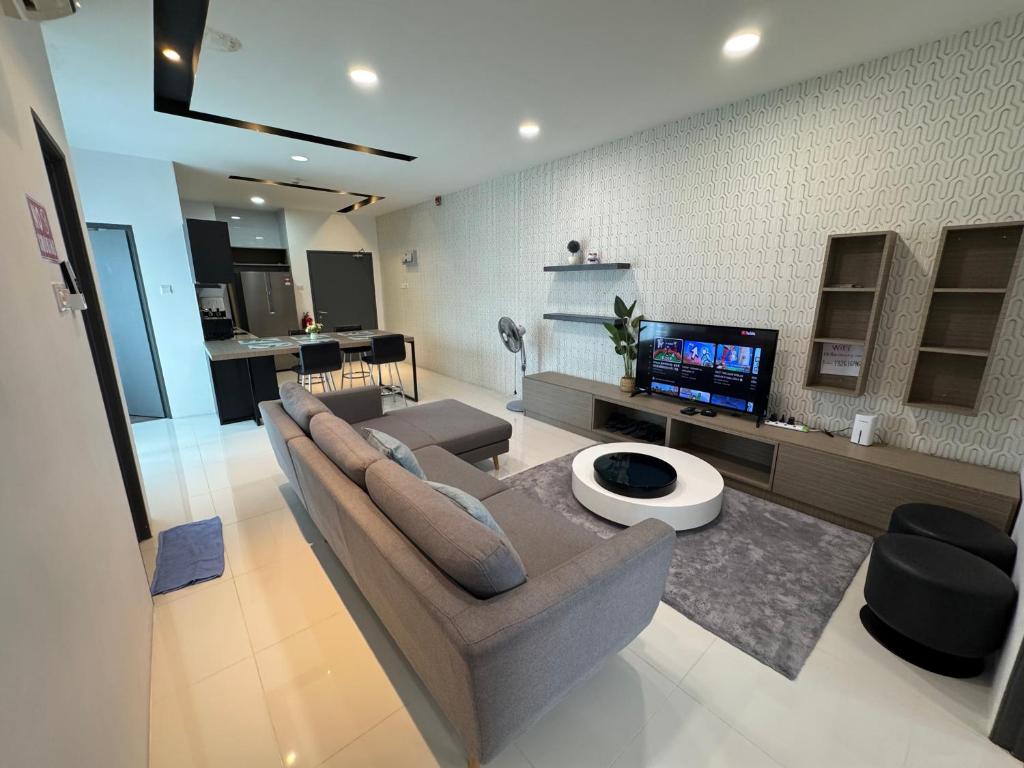a living room with a couch and a tv at Princeton Suite @Kuching Airport in Kuching