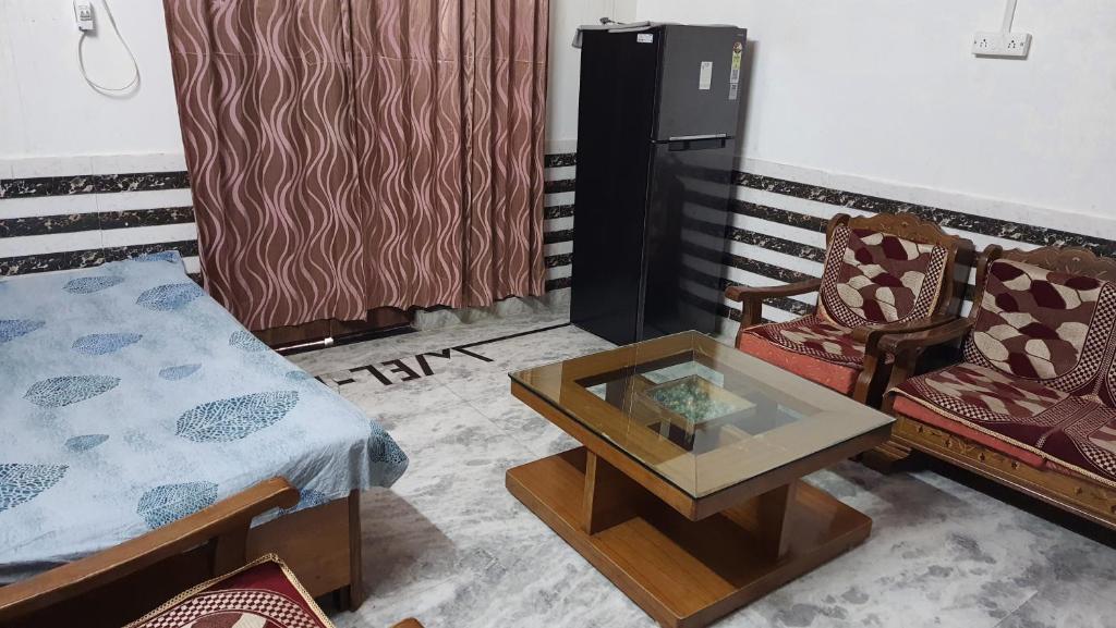 a room with a bed and a table and a chair at Radha Ras Homestay in Barsāna
