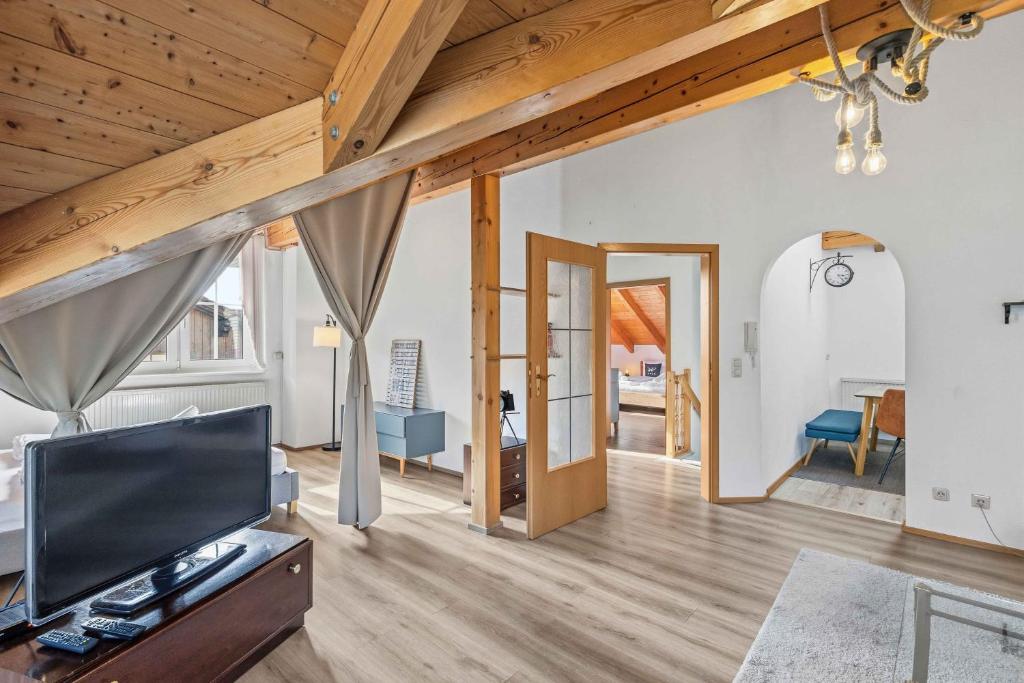 a living room with a television and wooden ceilings at Kuschelige Ferienwohnung mit Balkon & Free Wifi in Buchenberg