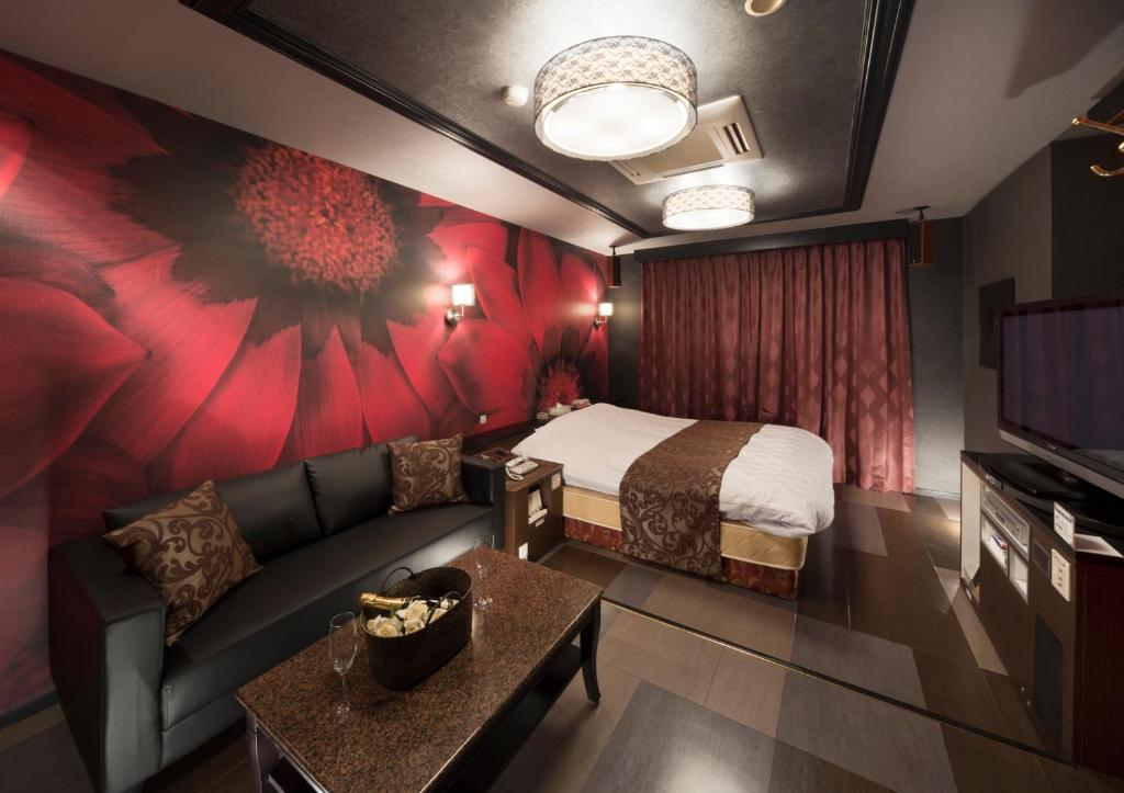 a hotel room with a couch and a bed at Hotel Antoinette -SPA RESORT- AdultOnly in Okazaki