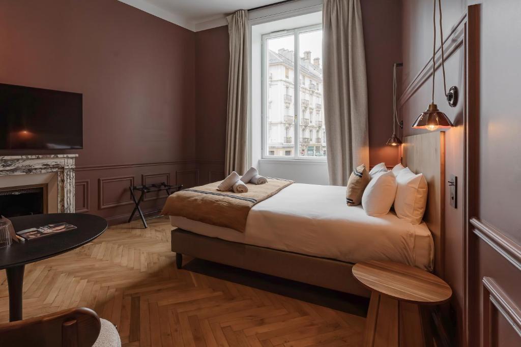 a hotel room with a bed and a window at La Maison des Ducs in Chambéry