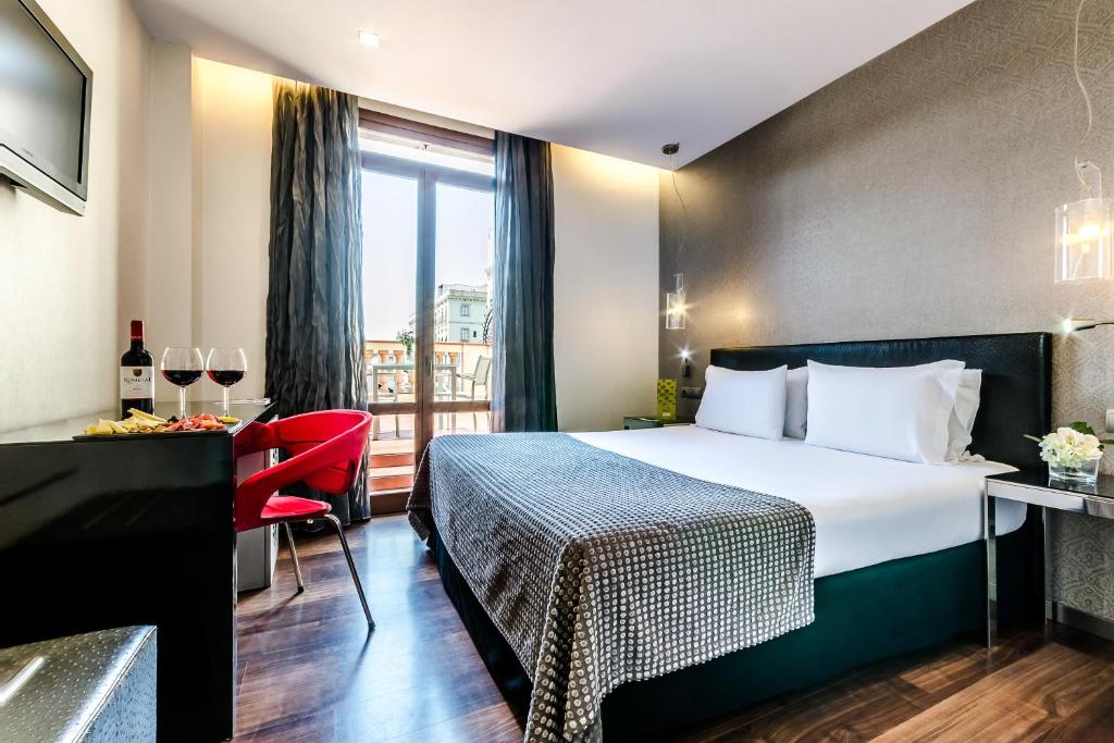 a hotel room with a bed and a window at Exe Ramblas Boquería in Barcelona