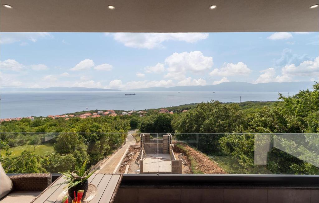 a view of the ocean from a house window at Lovely Apartment In Kostrena With Wifi in Kostrena