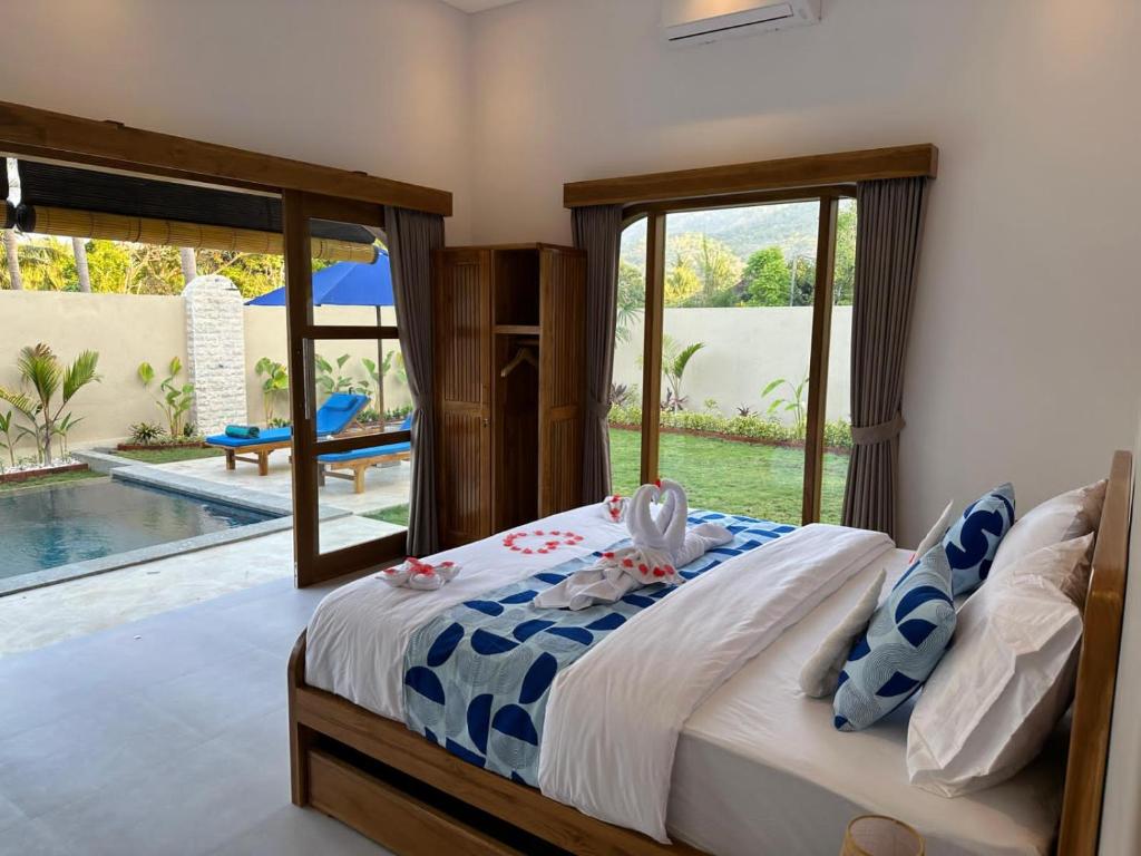 a bedroom with a bed with a view of a pool at Bukti Garden Villas in Bukti
