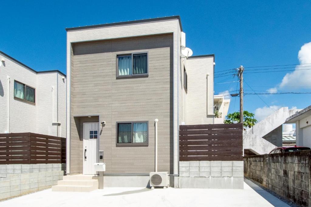 a house with a wooden fence in front of it at kafuulivimg sobe in Yomitan