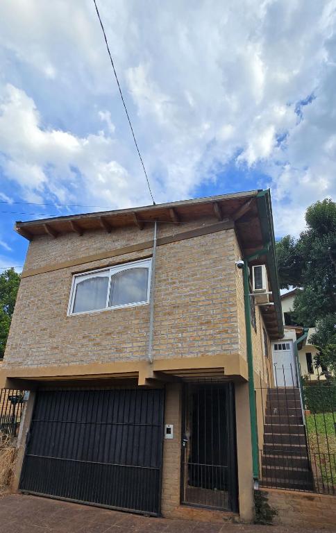une maison en briques avec un portail et un garage dans l'établissement Obera Monoambiente Completo, à Oberá