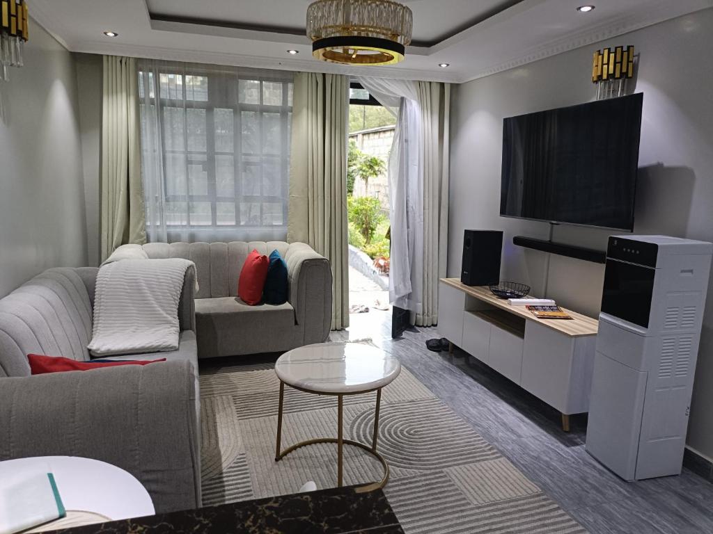a living room with a couch and a tv at Staycation by Winnie-Weber Generations -2 bedrooms in Nairobi