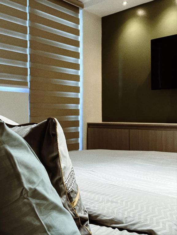 een slaapkamer met een bed en een flatscreen-tv bij Sequoia Suites at Azure North in San Fernando