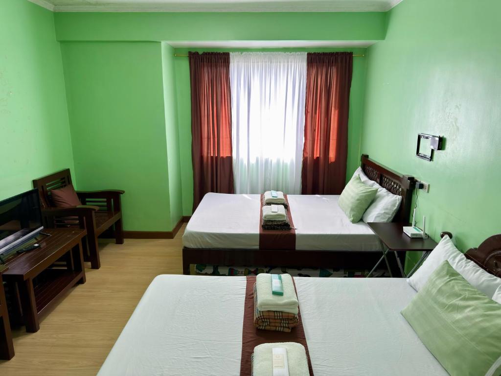 a hotel room with two beds and a window at Albergo Hotel - Studio Condo Unit - Baguio Transient in Baguio