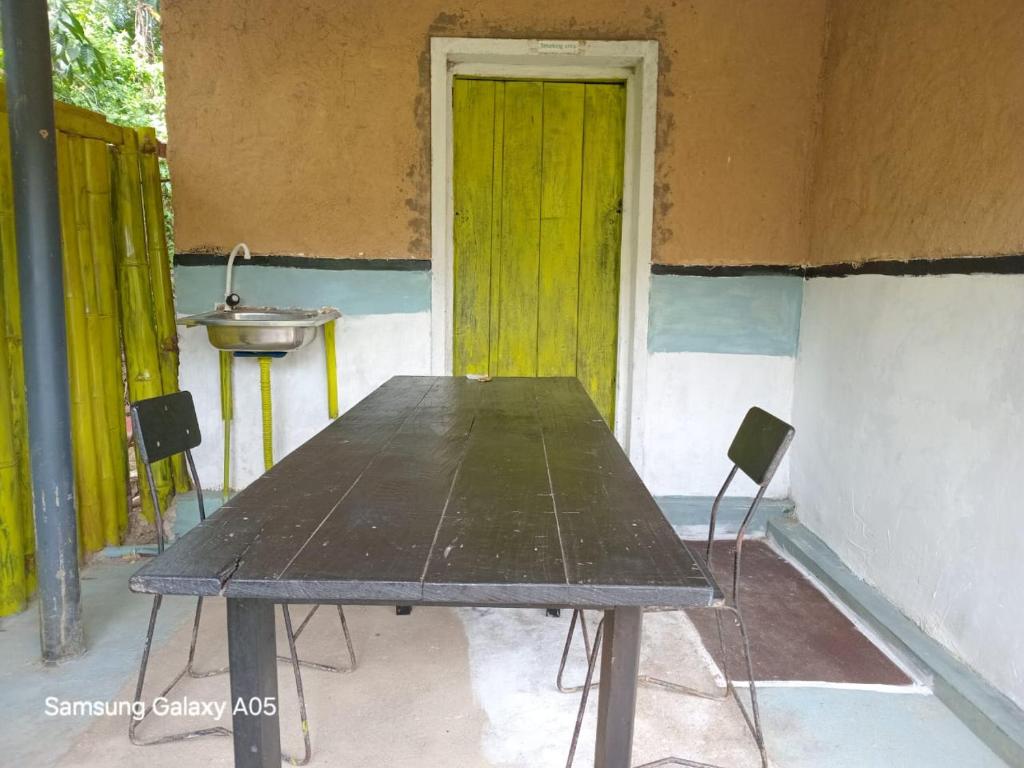 a table in front of a building with a green door at Ella Cool Air Cabana in Ella