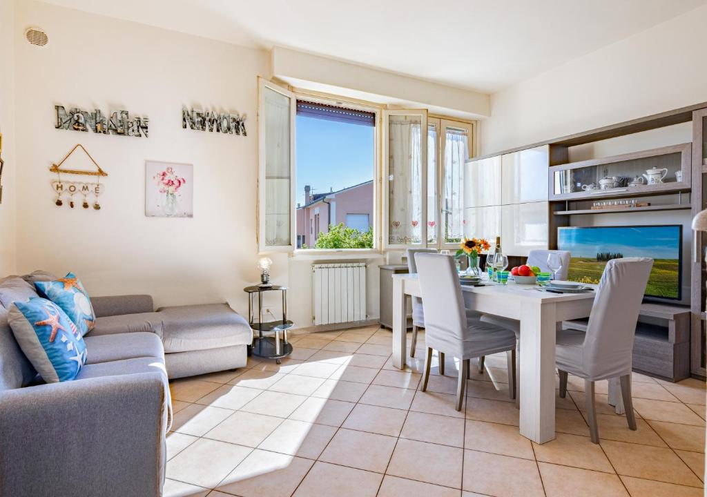 a living room with a couch and a table and chairs at Hostly-La Casa di Giada-Near Pisa, Lucca, Seaside in Navacchio