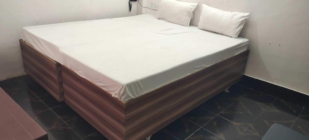 a bed with white sheets and pillows on it at Hotel O Home Crystal Cottage Home Stay in Ayodhya