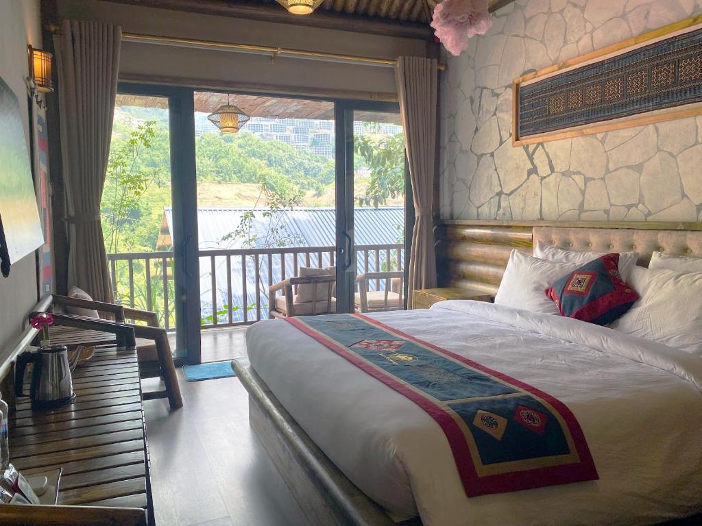Un dormitorio con una cama y un balcón. en Chapa Ecolodge, en Sa Pa