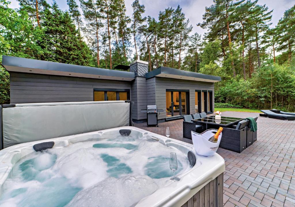 a jacuzzi tub in front of a house at Ferienhaus Waldblick mit Whirlpool und Sauna in Hellwege