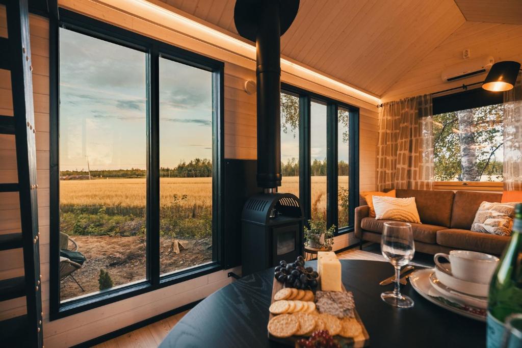 a living room with a table with wine glasses and a fireplace at Piilotupa in Inari
