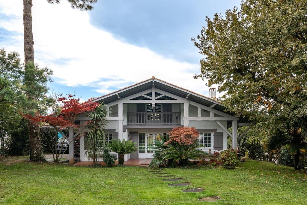 a white house with trees and a yard at Maison de vacances, Piscine & Plage à pied in La Teste-de-Buch