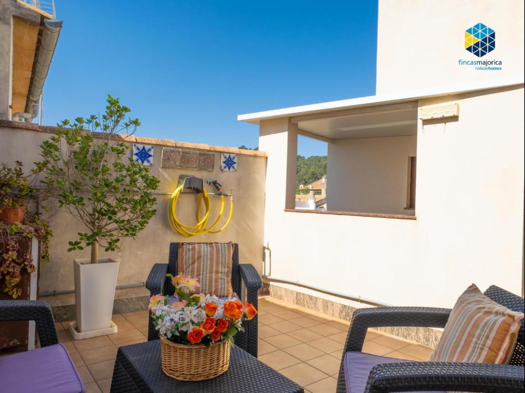 d'une terrasse avec 2 chaises et une table fleurie. dans l'établissement Can Guillem, à Pollença