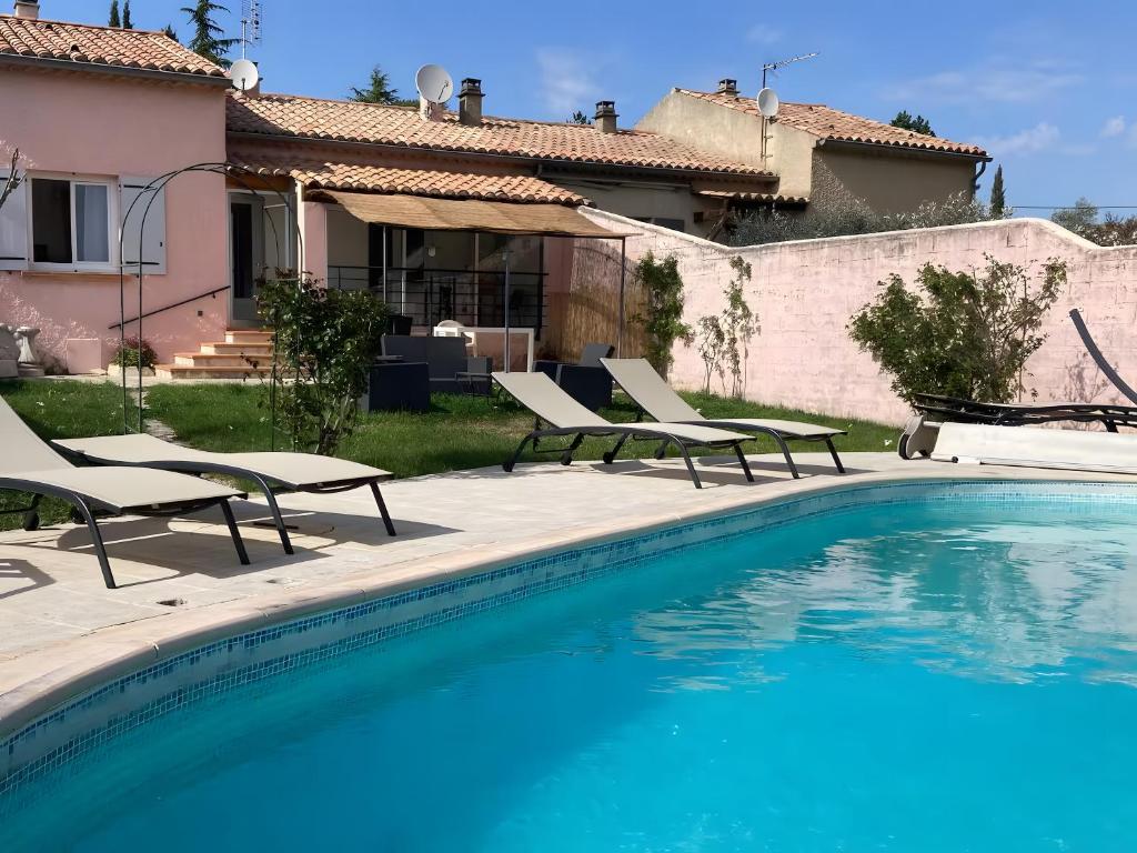 une piscine avec des chaises et une maison dans l'établissement Maison proche Vaison la Romaine, à Saint-Romain-en-Viennois