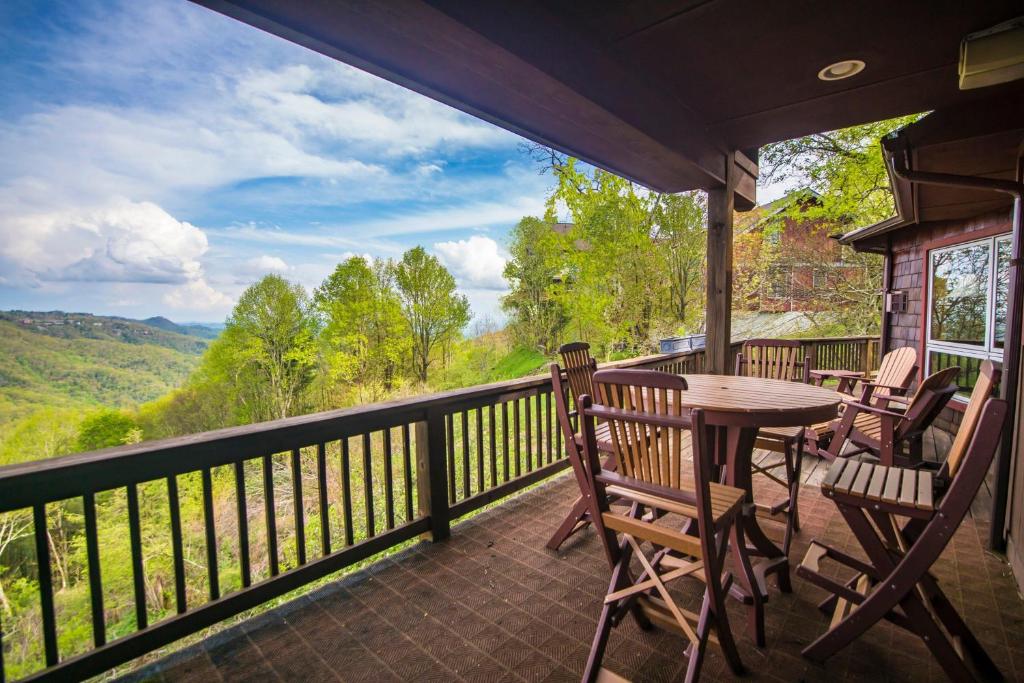 a porch with a table and chairs on a balcony at A Nest With a View in Blowing Rock