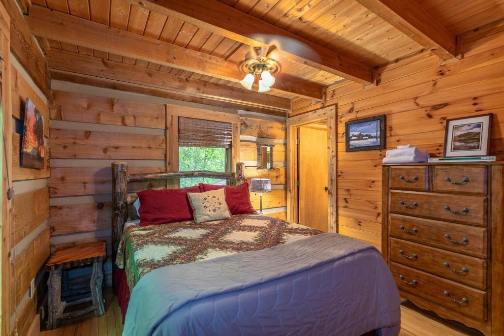 a bedroom with a bed in a log cabin at St Johns Ridge in Sugar Grove