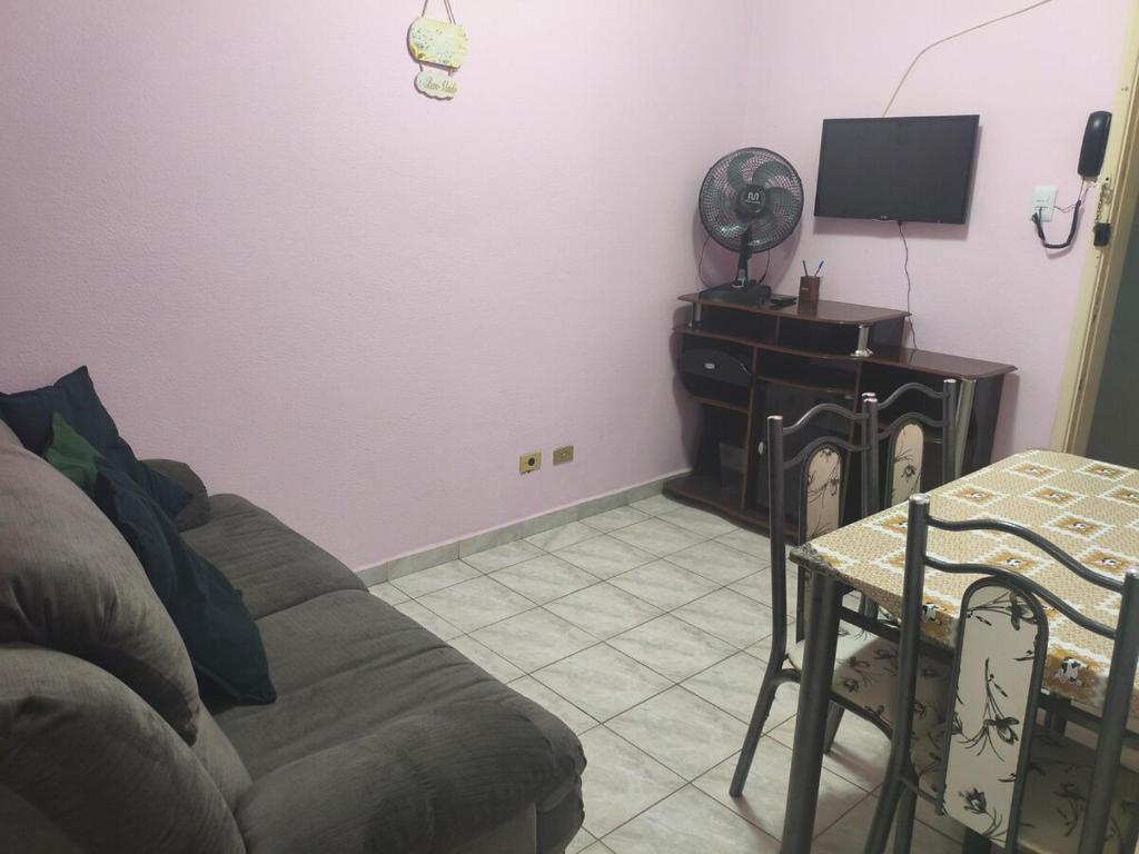 Kit do Rei - Boqueirão في برايا جراندي: غرفة معيشة بها أريكة وطاولة