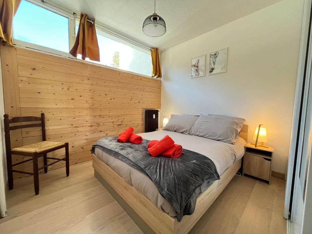 een slaapkamer met een bed met rode kussens erop bij A l'orée des bois in Égat
