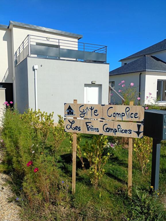 un panneau dans l'herbe devant une maison dans l'établissement Gîte à 400m de la mer, à Ploudalmézeau