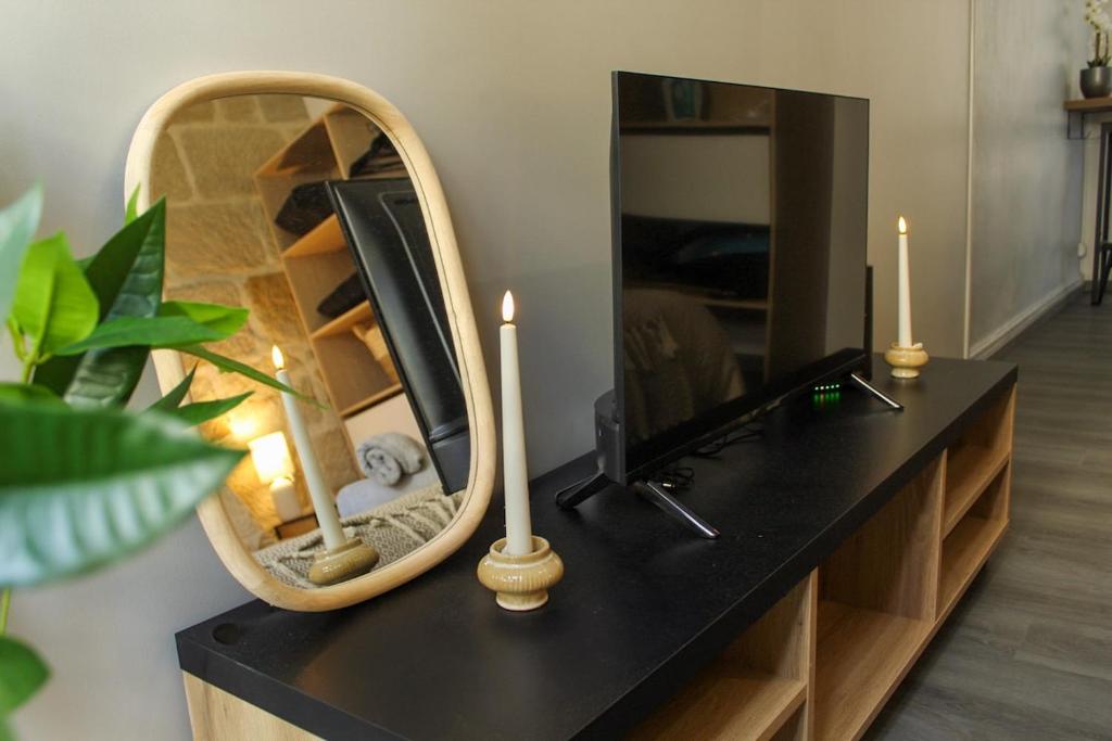 a mirror on a table with a tv and candles at Cozy Air-Conditioned - Central - Close to Train Station in Brive-la-Gaillarde