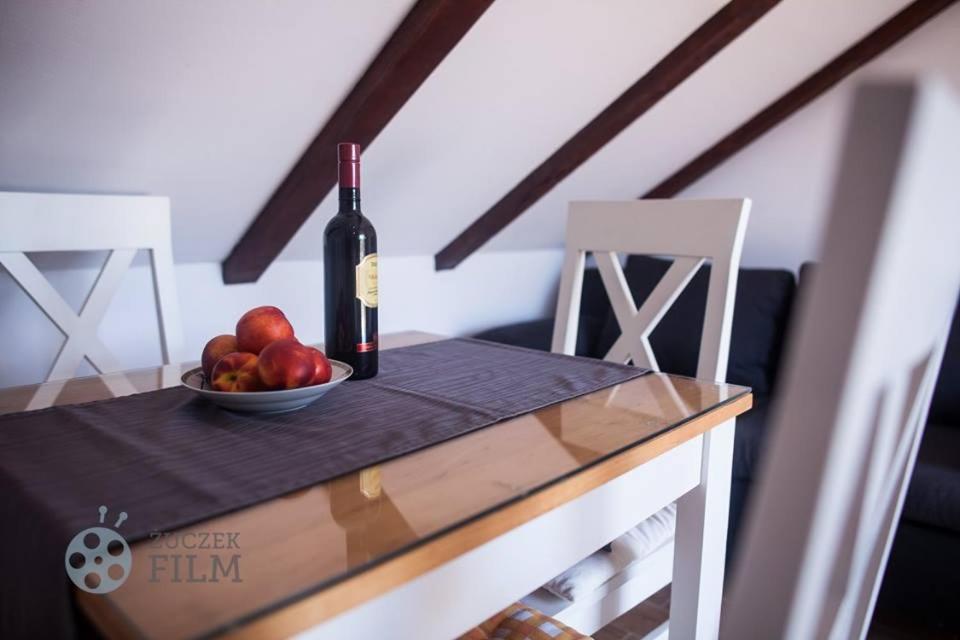 a table with a bowl of fruit and a bottle of wine at Villa Agava in Vrboska