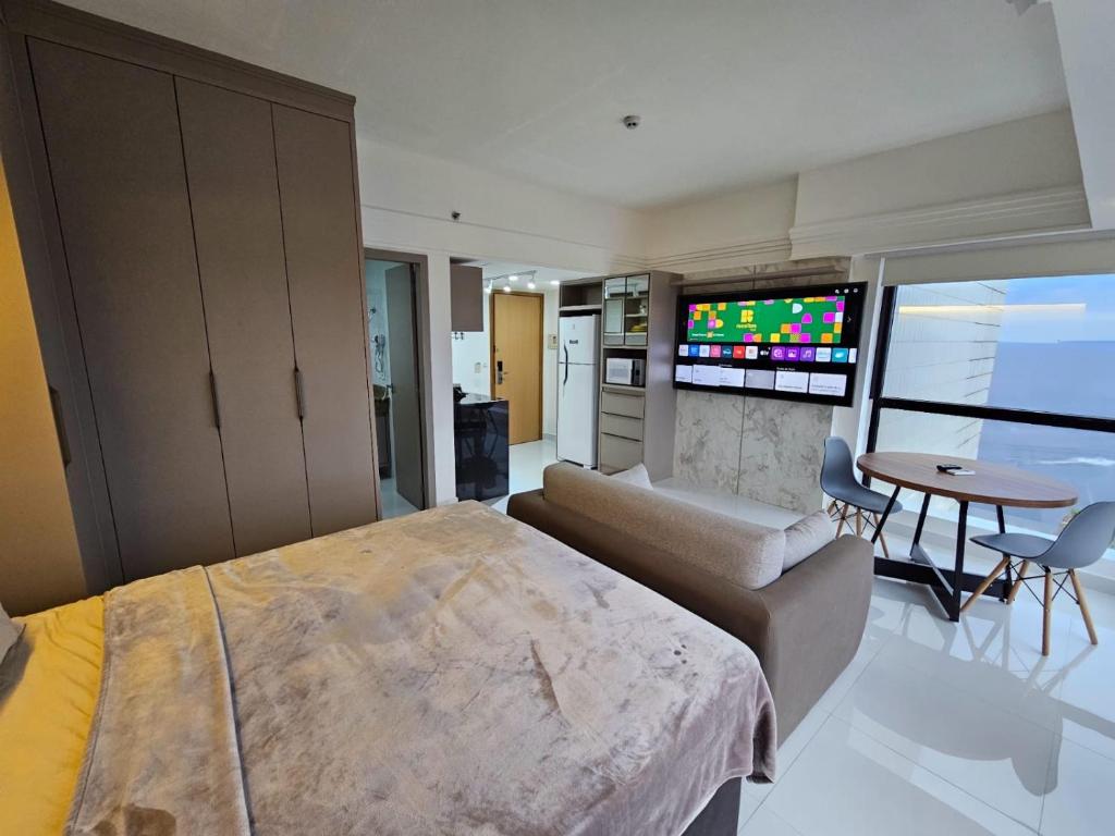 a bedroom with a large bed and a living room at Tropical Executive Flat in Manaus