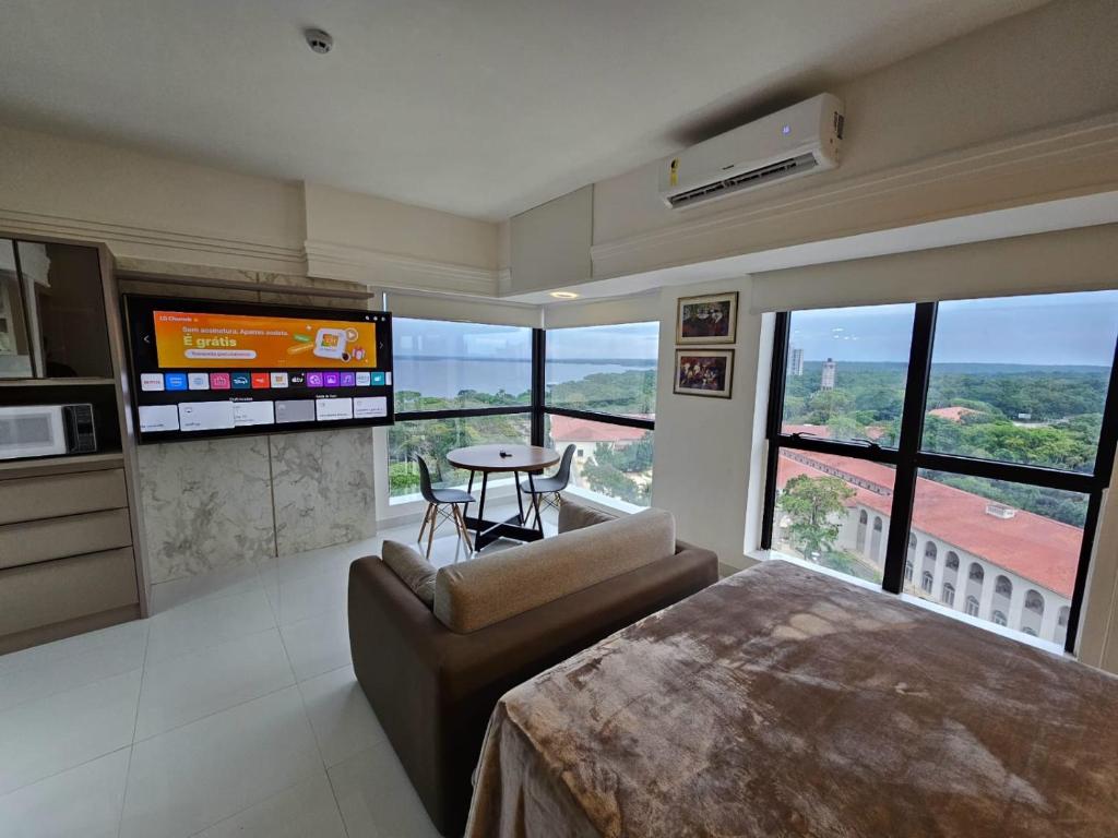 a living room with a television and a couch and a table at Tropical Executive Flat in Manaus