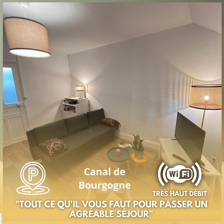 a living room with a green couch in a room at Le Comptoir du Canal in Fleurey-sur-Ouche