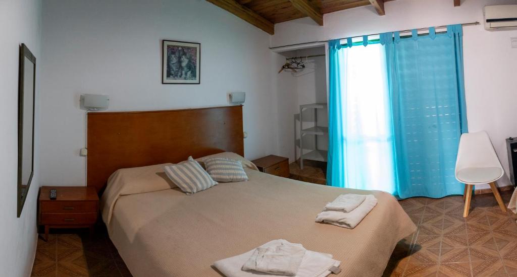 a bedroom with a bed with two towels on it at Bungalows Punta Azul in Villa Carlos Paz