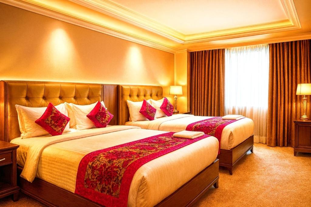 Una habitación de hotel con dos camas con almohadas rojas. en Boutique Hotel Almate - Near Delhi Airport With - free Airport Pickup, en Nueva Delhi