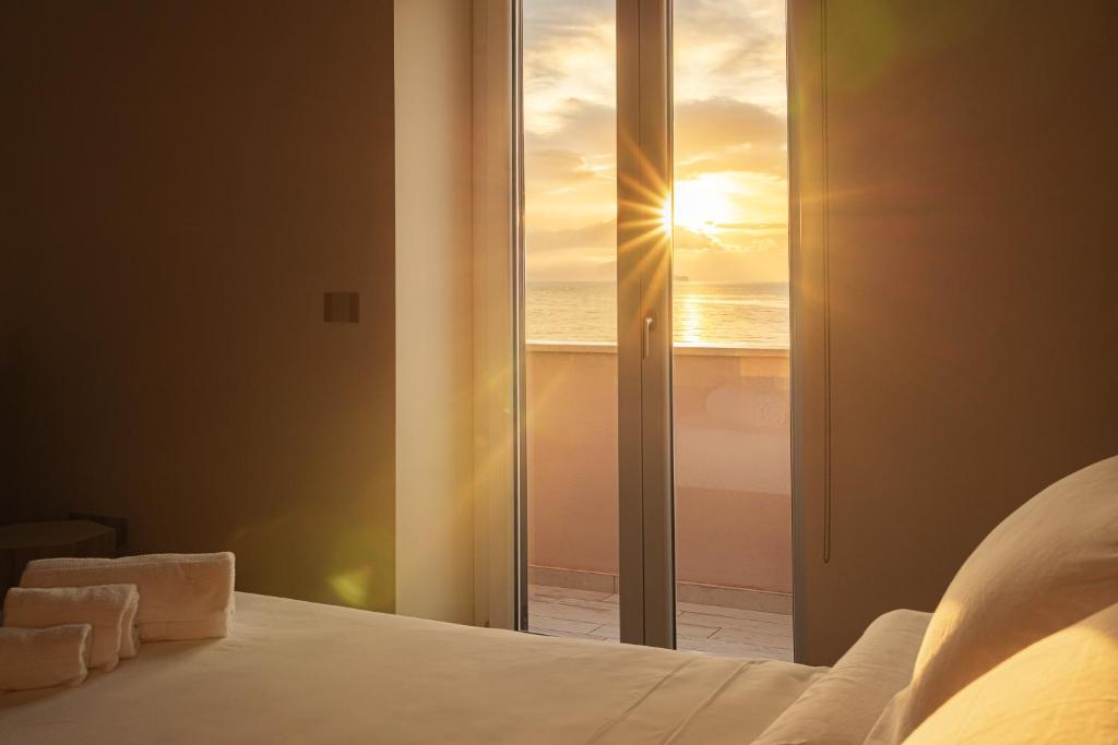 a bedroom with a bed with a view of the ocean at Sea Front House - Tono Milazzo in Milazzo