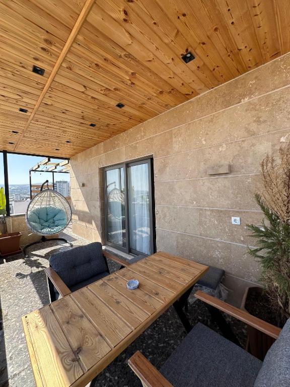 a wooden table and chairs on a patio at Stylish Loft Apartment with Private Terrace in Erdemli