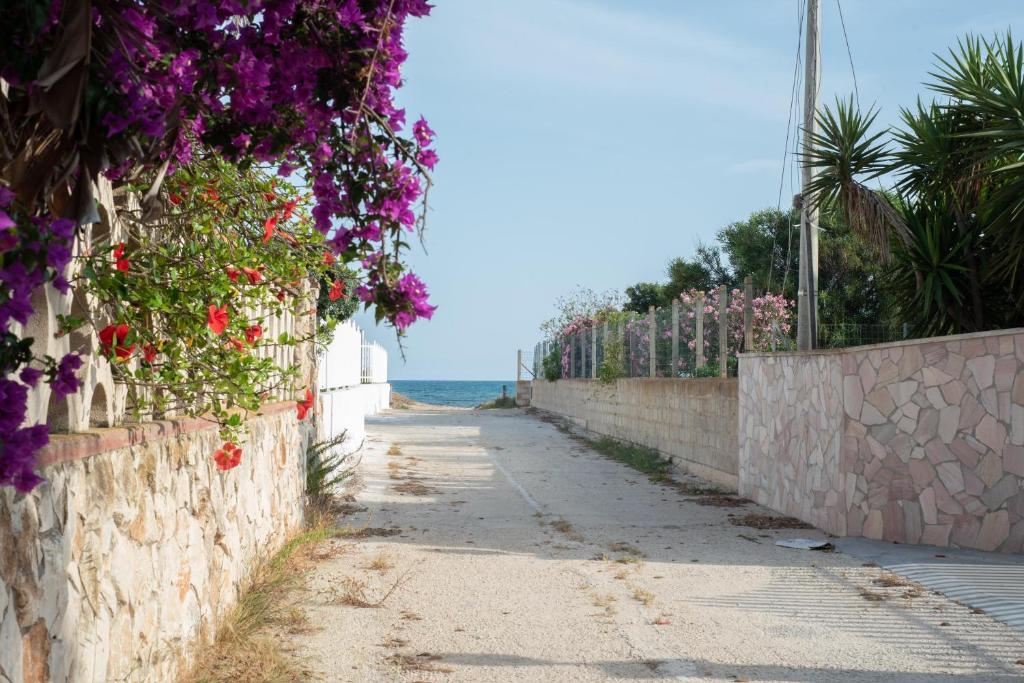 una strada con fiori su un muro vicino all'oceano di Love mer- Granelli a Granelli
