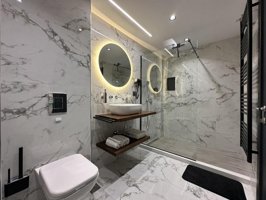 een badkamer met een toilet, een wastafel en een douche bij TrikalaBnB - Prime Loft 2 in Tríkala