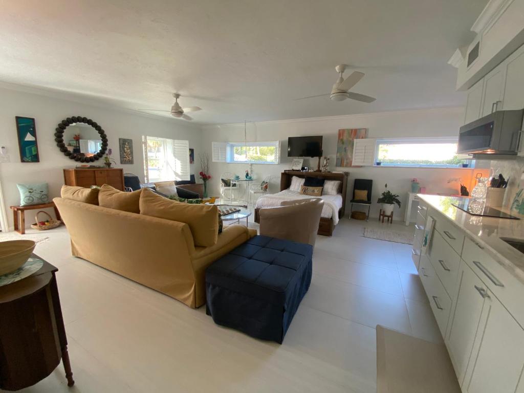 a kitchen and living room with a couch and a table at Closest Studio Suite to Vanderbilt Beach, remodeled inside & out, new Anderson windows & sliders, well appointed, best quality throughout, fenced yard, private plus many extras! in Naples