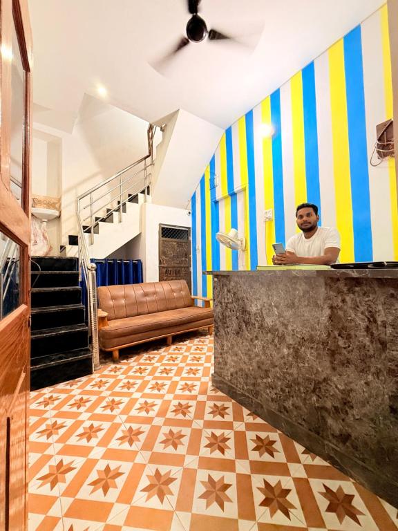 a man sitting at a counter in a living room at LA VACA Casa in Varanasi