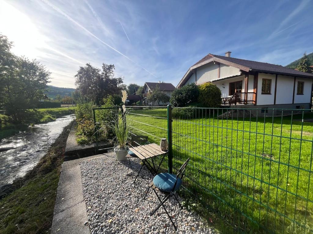 a bench in front of a fence next to a house at Haus am Fluss in Kirchberg am Wechsel